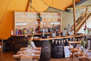 a bar in a tent with tables and chairs at Winsley Park Farm in Leominster