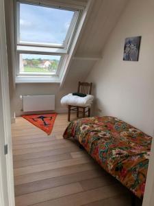 um quarto com uma cama, uma janela e uma cadeira em Luxe woonboerderij in de natuur. em Nieuwkoop