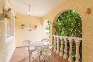 una sala da pranzo con tavolo, sedie e una finestra di Bungalow 145 a Santa Pola