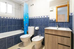 un bagno piastrellato blu con un water e un lavandino di Bungalow 145 a Santa Pola Altre 16 foto