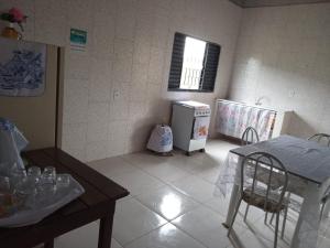 uma cozinha com uma mesa e um pequeno frigorífico em CASA TEMPORADA DONA CECÍLIA em Cavalcante