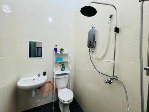 La salle de bains est pourvue d'une douche, de toilettes et d'un lavabo. dans l'établissement Khalish homestay, à Keluang