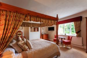 a bedroom with a canopy bed and a table at Blacksmiths Arms Inn in Scarborough