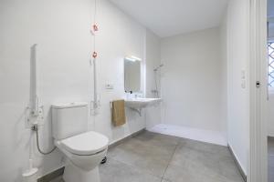 a white bathroom with a toilet and a sink at Residencia Universitaria Trinitarios in Valencia