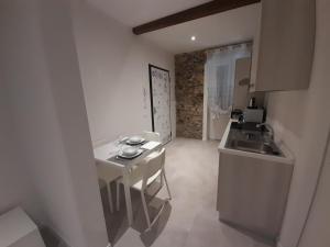 uma pequena cozinha com uma mesa branca e um lavatório em Appartamento Elia em La Spezia
