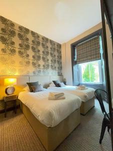 a hotel room with two beds and a window at Traquair Arms Hotel in Innerleithen