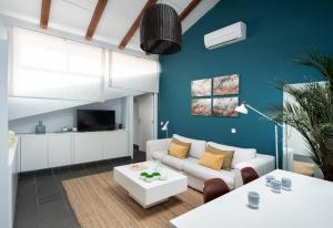 un soggiorno con divano bianco e parete blu di Carretas Attics Apartments a Madrid