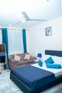 a bedroom with a bed and a couch at Semo's apartment in Bamburi