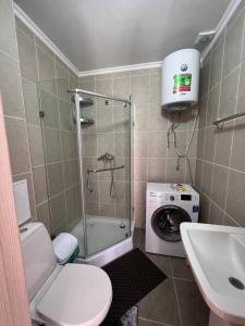 a bathroom with a shower and a washing machine at Townhouse 4/11 in Bosteri