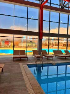 a pool in a building with lounge chairs next to it at Townhouse 4/11 in Bosteri