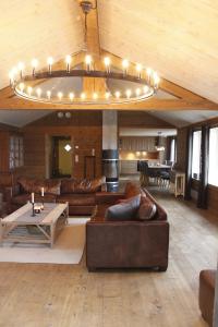a large living room with leather furniture and a chandelier at Sirdal Mountain Lodge, ski in-out in Sinnes