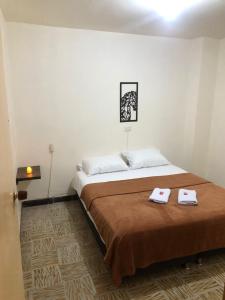 1 dormitorio con 1 cama con 2 toallas en Hostal El Marial e, en Marinilla