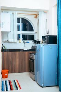 a kitchen with a blue refrigerator and a sink at Semo's apartment in Bamburi