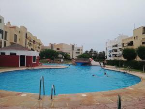 una gran piscina con 2 personas. en Primera linea de Playa de Martina en Almerimar