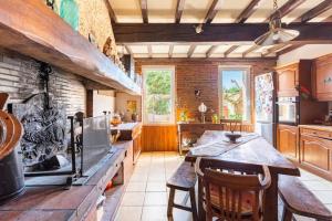 a large kitchen with a table and chairs in it at Escapade dans la campagne toulousaine in Beaumont-sur-Lèze