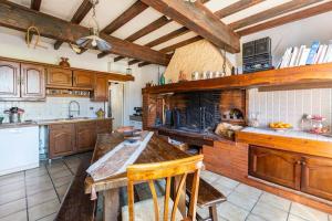 a large kitchen with wooden cabinets and a counter top at Escapade dans la campagne toulousaine in Beaumont-sur-Lèze