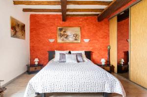 a bedroom with a large bed with an orange wall at Escapade dans la campagne toulousaine in Beaumont-sur-Lèze