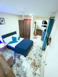 sypialnia z niebieskim łóżkiem i zmiażdżoną podłogą w obiekcie Semo's apartment w mieście Bamburi