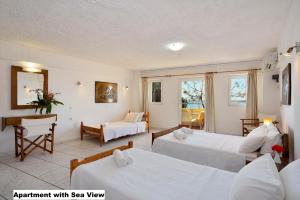 a hotel room with two beds and a desk at Katerina Rooms for Rent in Chania