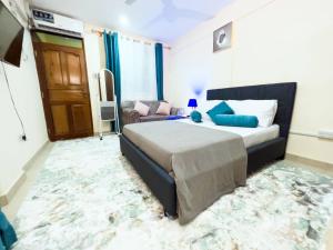 a bedroom with a bed and a couch at Semo's apartment in Bamburi