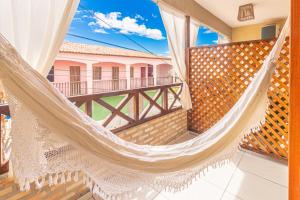 a hammock on the balcony of a house at Hotel Preá in Prea