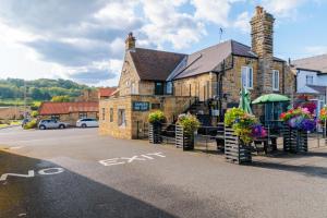 um edifício com flores ao lado de uma rua em Blacksmiths Arms Inn em Scarborough