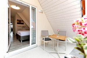 Habitación con balcón, cama y mesa. en Vinotel Weinstrasse en Herxheim am Berg