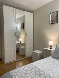 a bedroom with a large white closet with a mirror at BierzINN apartamento in Ponferrada