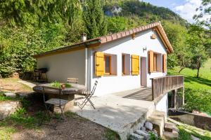 una pequeña casa blanca con puertas amarillas y una mesa en Quiet and Authentic Mountain Chalet, en Saint Pierre en Faucigny