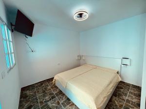 a small bedroom with a bed and a television at Casa Turquesa en Tazacorte in Tazacorte