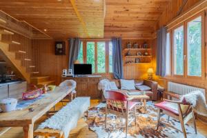 sala de estar con paredes de madera, mesa y sillas en Quiet and Authentic Mountain Chalet, en Saint Pierre en Faucigny