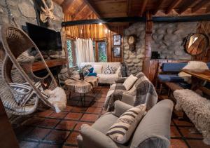 una sala de estar con sofás y sillas en una cabaña en Ruma Andina by DOT Cabana en Villa La Angostura