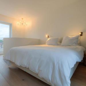 1 dormitorio con 1 cama blanca con sábanas y almohadas blancas en Unique Appartment view MAS! en Amberes