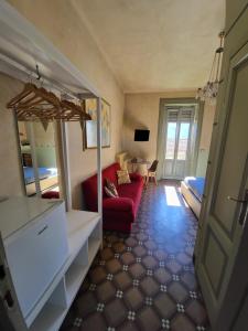 a living room with a red couch and a mirror at Bed & Breakfast Villa Palma in Lovere