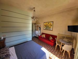 ローヴェレにあるBed & Breakfast Villa Palmaのベッドルーム(赤いベッド1台、赤いソファ付)