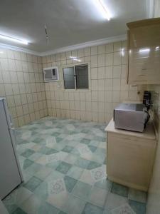 a kitchen with a tiled floor and a sink in a room at وحدة الأنس 3 in Al Madinah