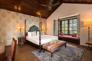 a bedroom with a bed and a bench in a room at Brij Anayra Dharamshala - A Himalayan Luxury Retreat in Dharamshala