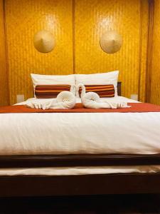 dois cisnes sentados em cima de uma cama em Danieli Resort em Hua Hin