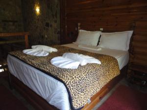 a bed with two pillows and a leopard print at Κalavrita eco View in Kalavrita