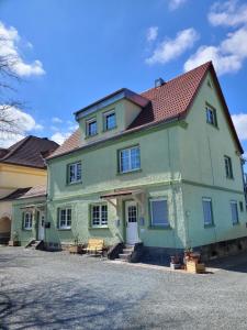 拜羅伊特的住宿－Ferienwohnung Kirsch 1，一座带红色屋顶的大型绿色房屋