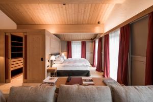 ein Hotelzimmer mit einem Bett und einer Couch in der Unterkunft Chalet Mimi in Oberlech + 18 Fotos