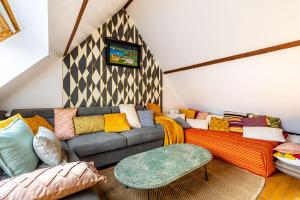 ein Wohnzimmer mit einem Sofa und einem TV in der Unterkunft Double Appartements 2&3 210 sqm up to 18 guests, Villa des Ammonites in Meudon