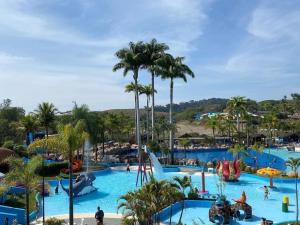 duży basen w parku rozrywki z ludźmi w nim w obiekcie Aldeia das Aguas Quartier w mieście Barra do Piraí