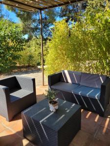 une terrasse avec deux chaises, un canapé et une table dans l'établissement Studio dans maisonnette en pierre, au Castellet