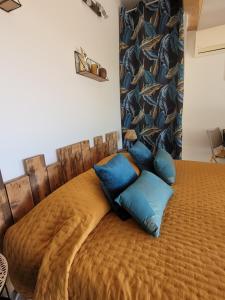 - un lit avec des oreillers bleus au-dessus dans l'établissement Studio dans maisonnette en pierre, au Castellet