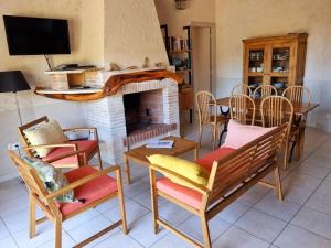 a living room with a fireplace and a table and chairs at CORSACASA Villa in Palombaggia sea view in Porto-Vecchio