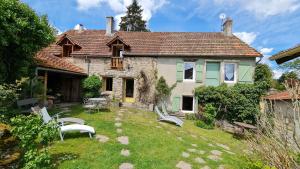 a house with a yard with chairs in front of it at Chambres d`hôtes Le Plessis in Broye