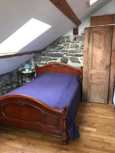 um quarto com uma cama e uma parede de pedra em Maison de famille plateau du Mezenc em Les Vastres