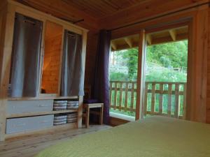 a bedroom with a bed and a large window at CHALET BOIS PLEINE NATURE 6 PLACES in Sainte-Eulalie-dʼOlt