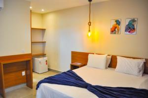 1 dormitorio con 1 cama con manta azul en Pousada WOOD SUITES, en São Miguel do Gostoso